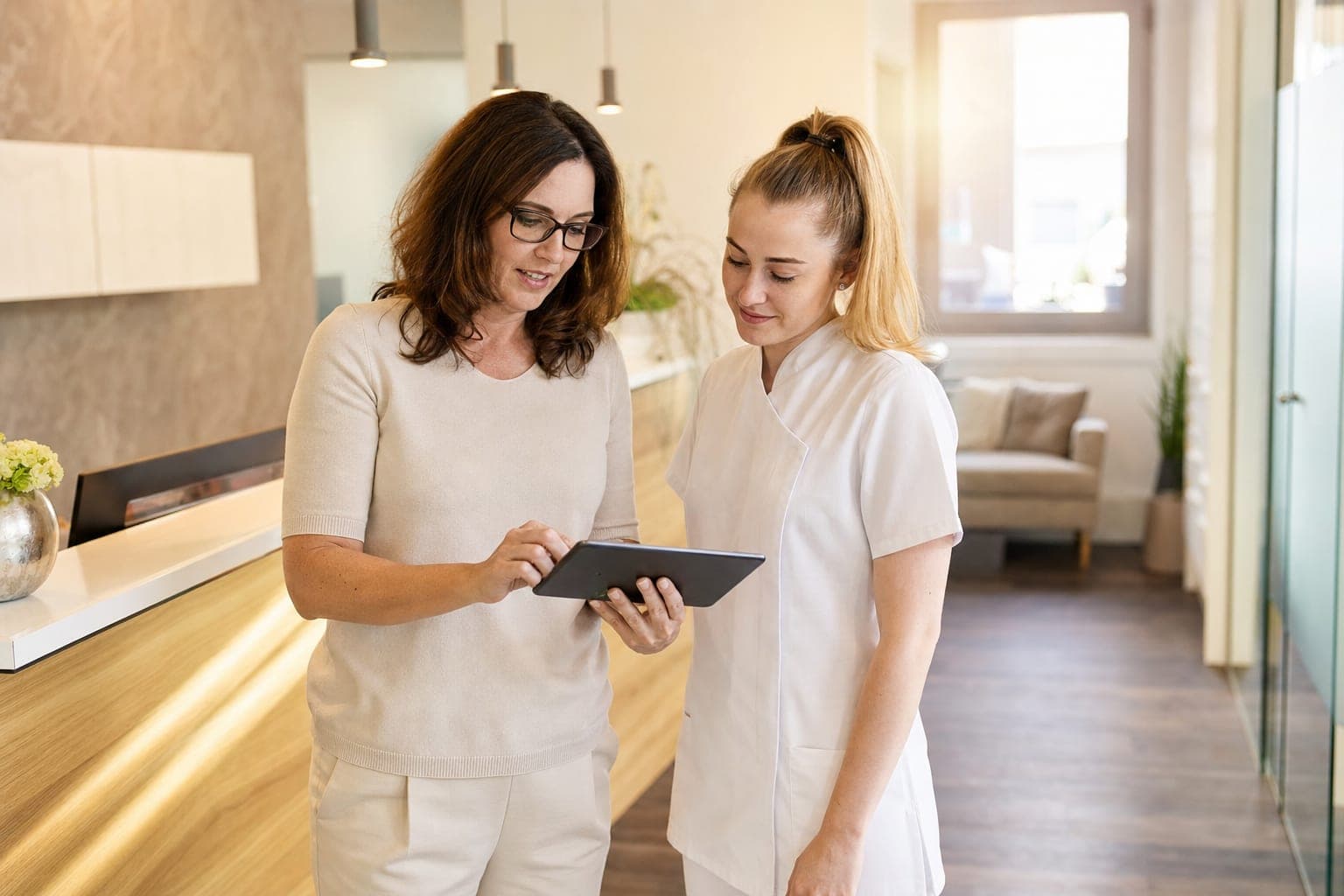 Betriebsinhaber und neue Fachkraft am Tablet in der Werkstatt